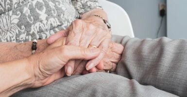 Elderly person holding hands